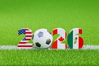 2026 cut out numbers as an American flag, soccer ball, Canadian flag and Mexican flag patterns glaon a football field