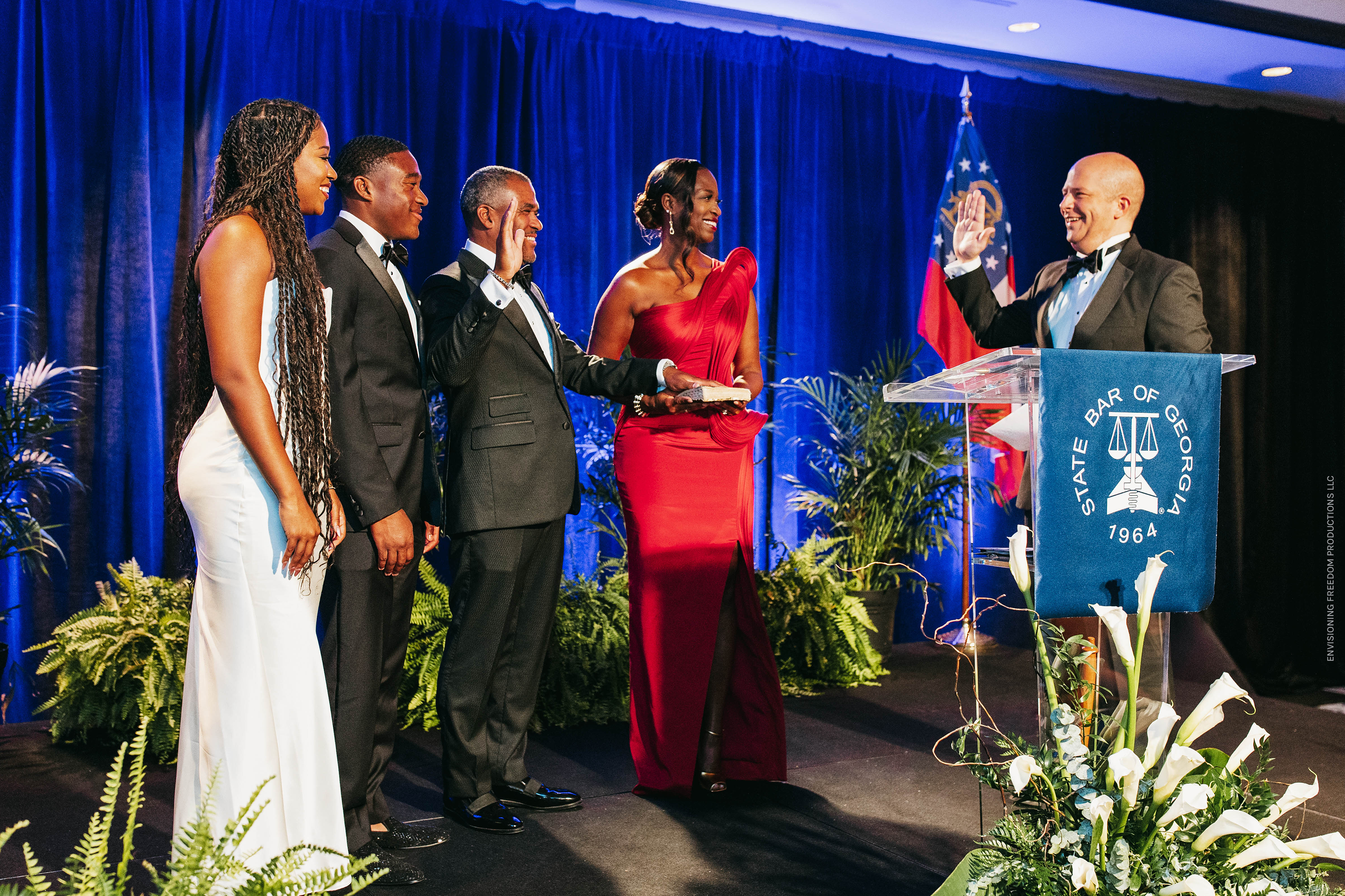 A man stands proudly with his hand on the Bible surrounded by his family as he takes his inaugural oath.