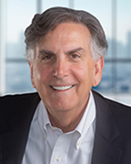 A man in a navy suit jacket and white dress shirt.